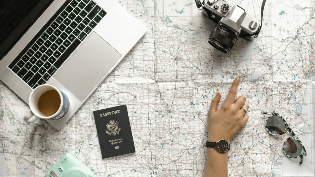 Planificando un viaje sobre un mapa con pasaporte y portátil